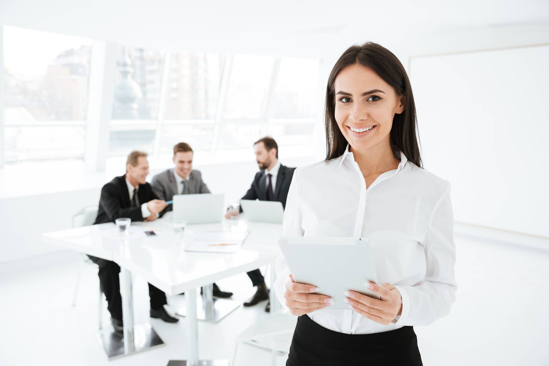 business woman standing office with business group background holding docume